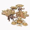 Golden Diwali tealight holder set featuring detailed elephant and butterfly motifs, lotus flower-shaped bases, and multiple diya cups, arranged on a clean white background.