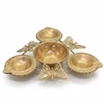 Golden butterfly-themed diya holder with four decorative diya compartments arranged around a central bowl, ideal for festive or puja decor.